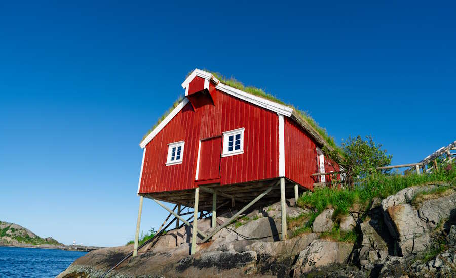 såhär kan grundläggning se ut på västkusten där har man träpålar som förankrats i udden som i sin tur består av synligt berg och sten