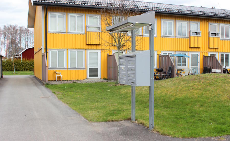 radhusområde med fristående monterade fastighetsboxar placerade under skärmtak med belysning lagom höjd och smidig åtkomst det blir inte bättre än såhär